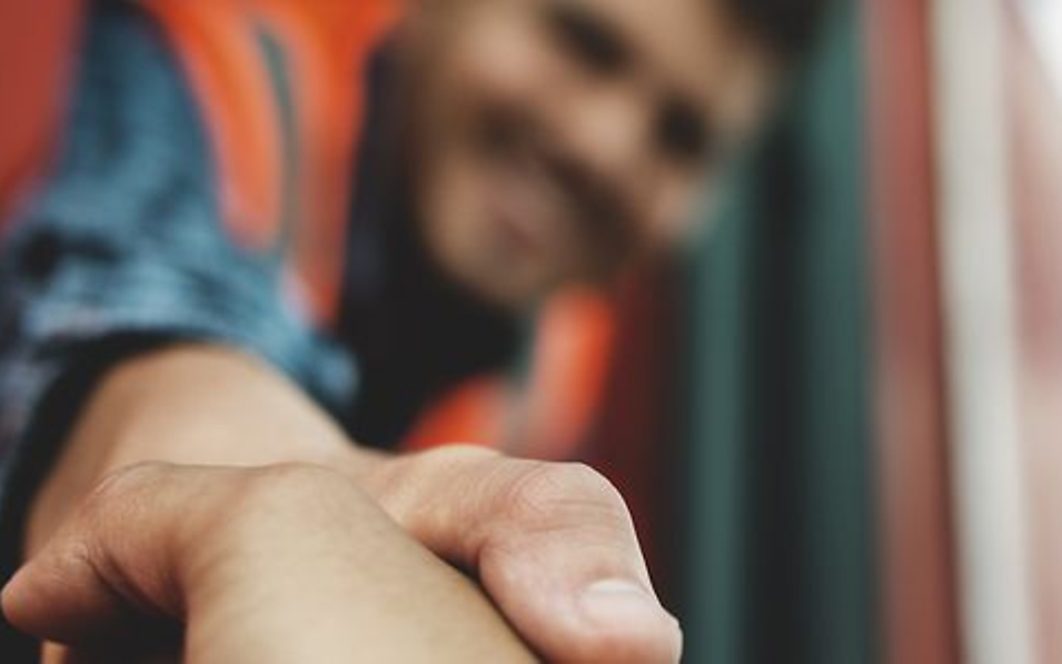 Mitarbeiter schüttelt Hand aus dem Zug